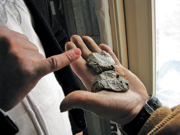 The construction supervisor checks that the new tinted mortar duplicates the building's original smoke-darkened mortar.